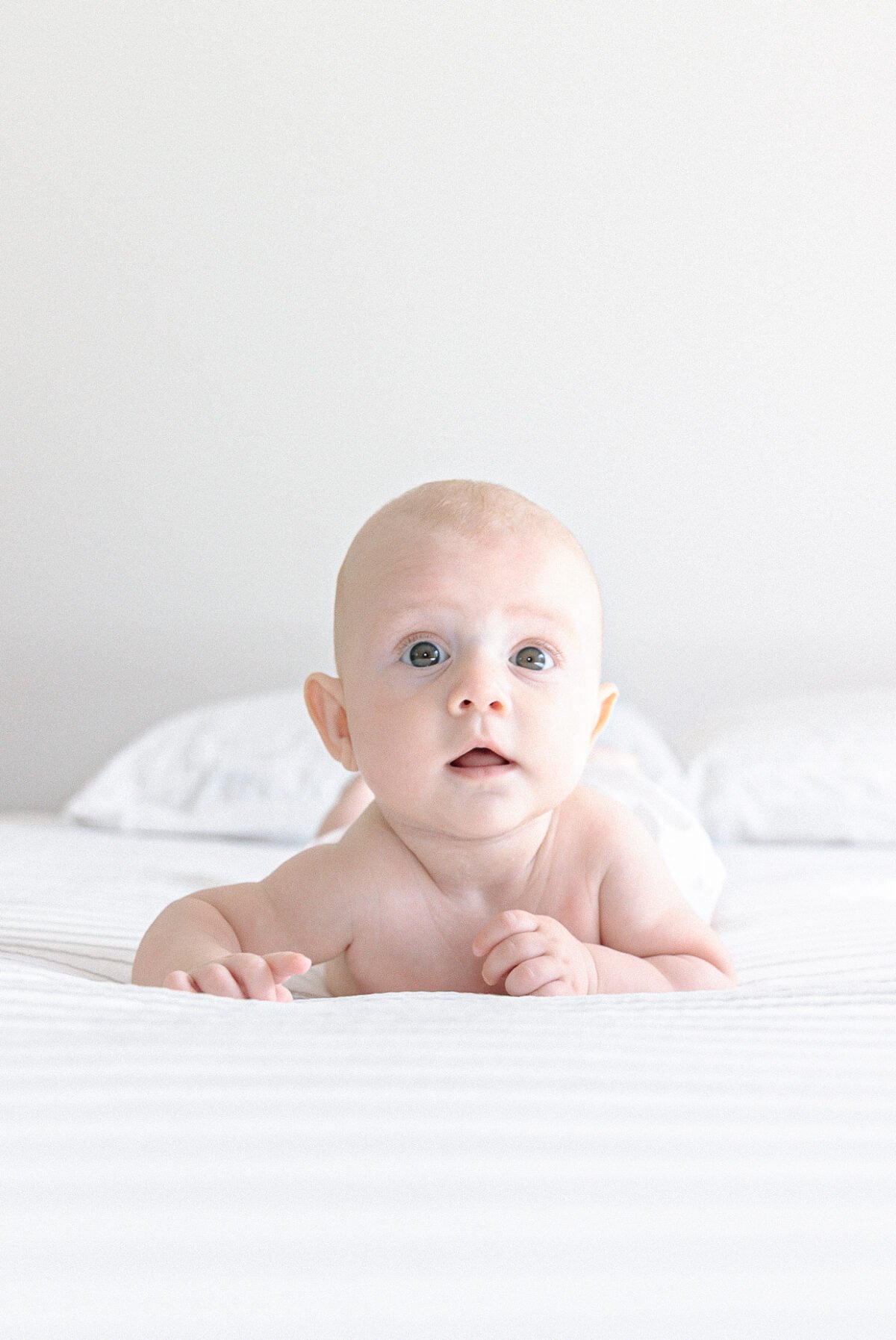 Bébé sur le it face à l'objectif beaux yeux bleus