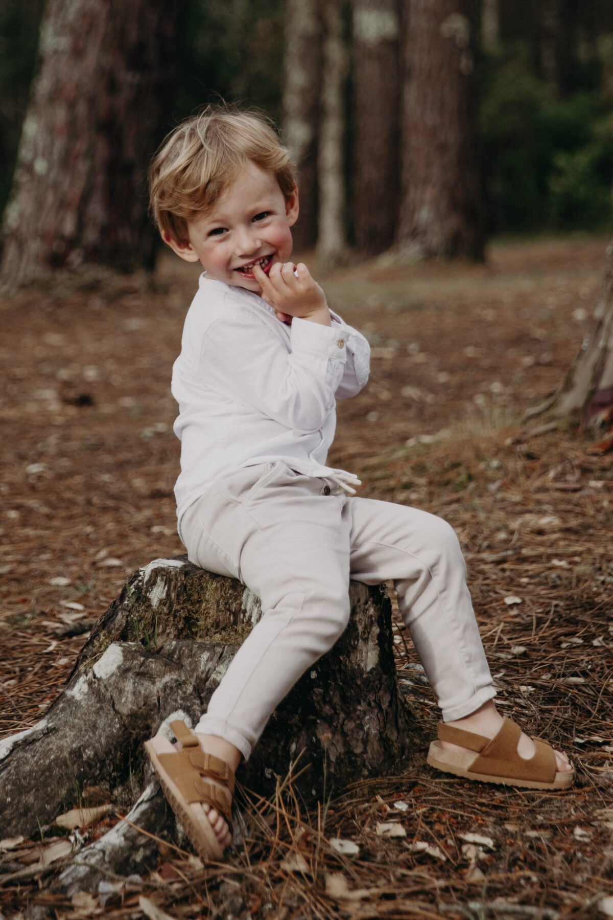 portrait petit garçon au courant d'huchet assis sur un tronc d'arbre landais